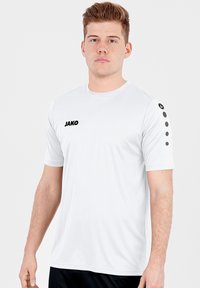 White athletic T-shirt with round neckline, short sleeves, black "JAKO" logo on the chest, and three black circles on the shoulder.
