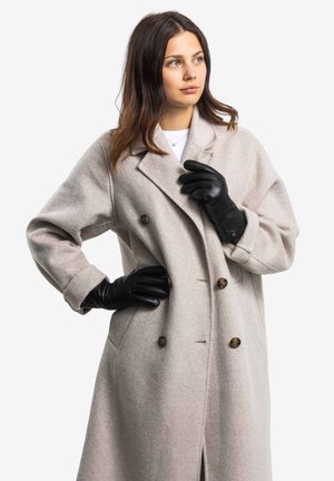 Light gray wool overcoat with a double-breasted design, large buttons, and side pockets. Worn with black leather gloves.