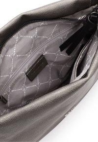 Wnętrze torebki z metalicznej szarej skóry z zamknięciem na zamek, z wzorzystą szaro-skalą podszewką oraz wieloma kieszeniami do organizacji.