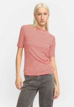 Röd och vit randig åtsittande t-shirt med korta ärmar, rund hals och mjuk textur. Matchad med grå höga byxor.