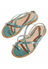 Błyszczące turkusowe sandały z krzyżującymi się paskami, teksturowanym wierzchem oraz naturalną podeszwą z małymi metalicznymi ćwiekami wzdłuż obwodu.
