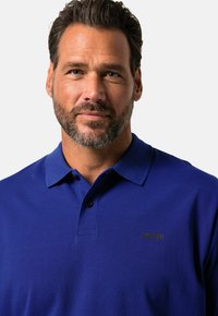 Polo shirt blu royal con colletto, maniche corte e logo nero "JP1880" sul lato sinistro del petto. Tessuto leggero.