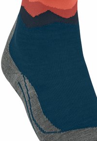 Calzini alla caviglia in teal con una texture, caratterizzati da un motivo gradiente in corallo, blu navy e grigio. Realizzati in maglia con aree del tallone e della punta rinforzate.