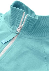 Jasnoniebieska kurtka zapinana na zamek z prążkowanym kołnierzem, białym zamkiem błyskawicznym i małą niebieską metką z gwiazdką. Miękka tekstura, casualowy fason.