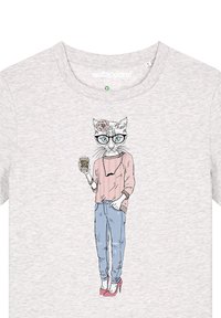 Lichtgrijs T-shirt met een grafische illustratie van een kat in een bril en een roze trui, die een koffiekopje vasthoudt, met een blauwe jeans en roze hakken.