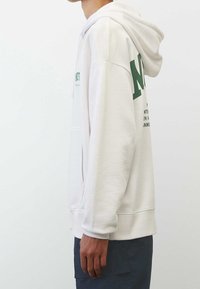 Sudadera de color gris claro hecha de tela texturizada, con un bolsillo frontal. Presenta texto impreso en verde y una capucha con cordón. Puños y bajo acanalados.