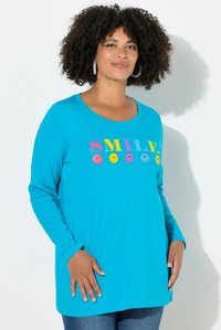 Türkisfarbenes Langarm-T-Shirt mit dem Schriftzug "SMILE" und bunten Smiley-Gesichtern. Weicher Stoff mit lockerem Schnitt, rundem Ausschnitt und gerippten Ärmeln.