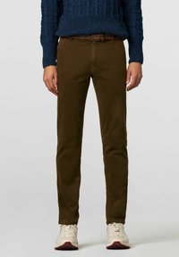 Olijfgroene corduroy broek met een slim fit, medium taille en vijf-pocket ontwerp, gecombineerd met een kleurrijke gevlochten riem en witte sneakers.