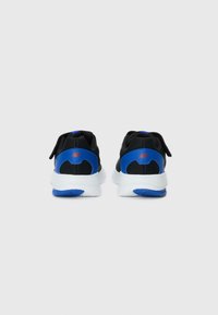 Chaussures de sport noires avec des accents bleus, en tissu en maille, dotées d'une semelle blanche rembourrée et de lacets pour un maintien sûr.