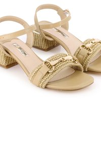 Sandalias beige con tiras, un acento tejido y detalles en dorado, con punta cuadrada y un tacón bloque texturizado.