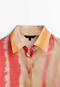 Leichtgewichtige Button-Up-Hemd aus weichem Stoff mit einem Muster aus orange, pink und beige Streifen. Klassischer Kragen mit einem einzigen Knopfverschluss.