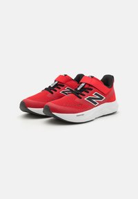 Baskets de sport rouges avec tige en maille, accents noirs et bandes Velcro. Semelle en mousse blanche marquée "FRESH FOAM". Bout arrondi et semelle texturée.