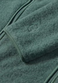 Green fleece jacket featuring a smooth texture, zip closure, and elastic cuffs. Includes a small embroidered logo detail.