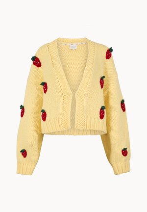 Keltainen neulottu lyhyt neuletakki, jossa on punaisia mansikkakuvioita hihoissa ja edessä, syvä V-kaula-aukko sekä resorit hihansuissa ja helmassa.