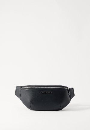 Must must nahkmehhanism, millel on tekstureeritud pind ja hõbedane tõmblukk. Omab lame rihma mugavaks kandmiseks ja esiküljel logoplakaati.