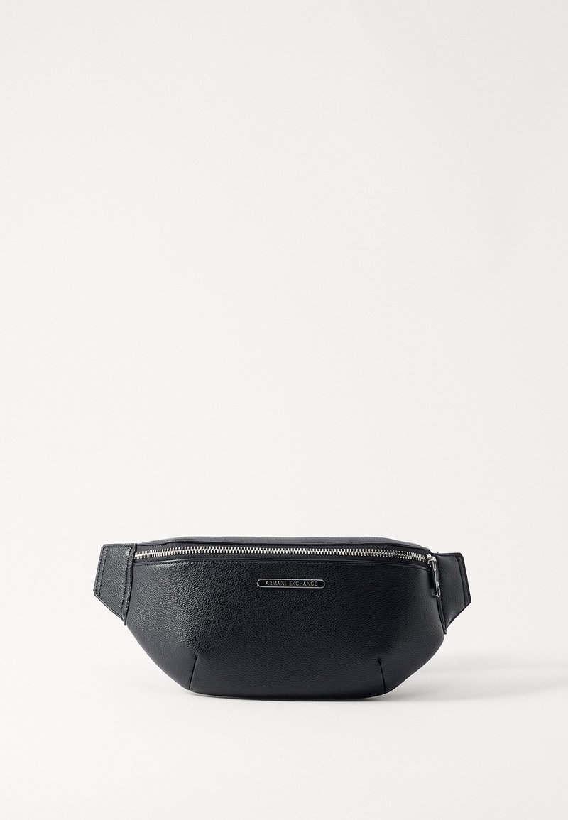 Banane en cuir noir avec une surface texturée et une fermeture éclair silver. Dispose d'une sangle plate pour un port facile et d'une plaque de logo à l'avant.