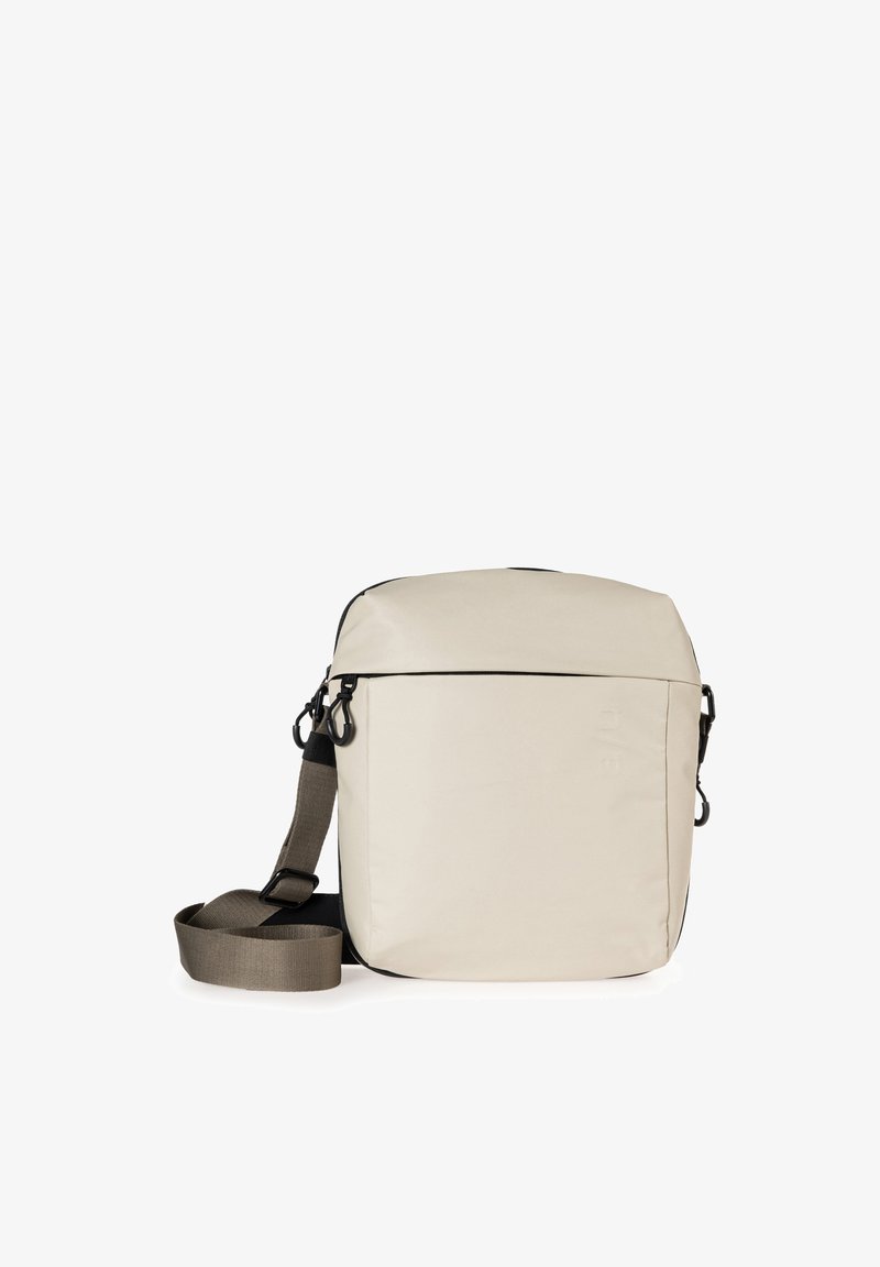 Borsa a tracolla in tessuto beige con forma rettangolare, dettagli in zip neri e tracolla regolabile color khaki. Texture liscia, design minimalista.