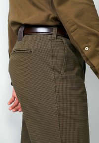 Bruine geruite broek van gestructureerde stof, met een getailleerde pasvorm, zijzakken en een donkerbruine leren riem.