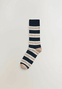 Gestreifte Socke in Marineblau, Creme und Beige. Hergestellt aus einem strukturierten Stoff mit einem gerippten Bündchen und einer runden Zehenpartie.