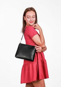 Černá kožená kabelka s hladkou texturou a zlatým kováním. Má nastavitelné rameno a přední kapsu. Jednoduchý obdélníkový tvar.