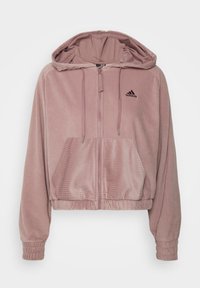 Sweat à capuche court zippé en velours côtelé rose pâle, doté d'une capuche, de poignets côtelés et d'un logo noir brodé sur la poitrine.