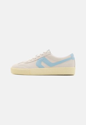 Baskets en daim beige avec des accents bleu clair et une semelle en caoutchouc crème texturée. Dotées de lacets blancs et d'un design minimaliste.