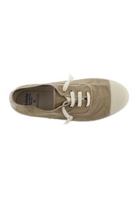 Zapatillas de lona beige con cordones blancos, puntera redondeada y parte superior texturizada. Presenta una etiqueta en el interior y pequeños adornos decorativos.