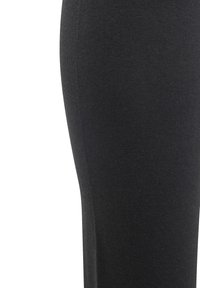 Leggings negros hechos de una mezcla de algodón elástico, con una textura suave y un diseño ajustado, mostrando un primer plano del área de la pierna.