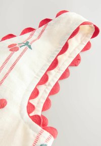 Material alb cu margine roșie ondulată, dungi cusute roșu și cireșe mici roșii cu frunze verzi brodate pe marginea țesăturii.