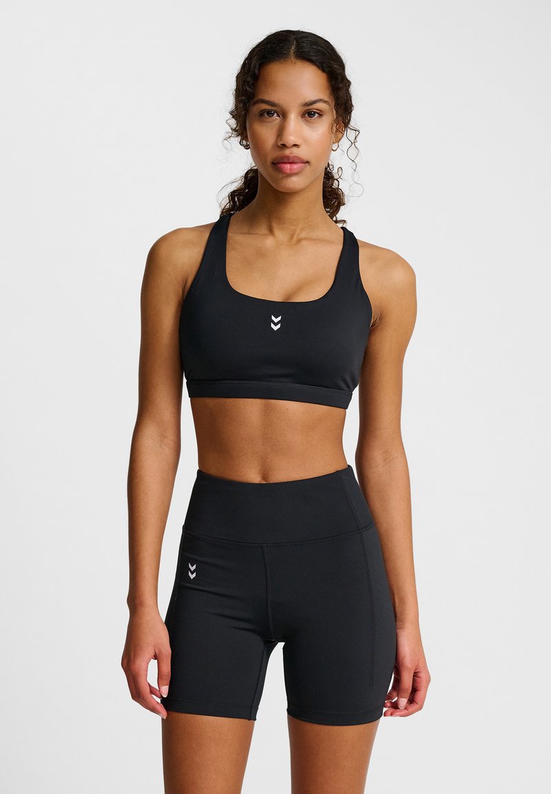 Svart idrottsbehå och högmidjade shorts i ett slät och stretchigt material, med en liten logotyp i mitten och en åtsittande design.