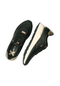 Svarta träningsskor med en strukturerad läderöverdela, som har guldiga detaljer, en krämfärgad sula och svarta snören.