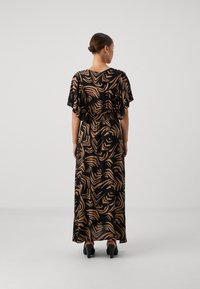 Svart maxi-kjole med abstrakt beige mønster, fløyelsærmer, elastisk midje, teksturert stoff. Brukt med svarte hæler.