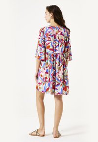 Kleurvolle shift jurk met korte mouwen, bloemenpatronen in tinten van roze, blauw en oranje; getailleerde taille en losse, vloeiende rok.