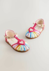 Színes gyerek szandálok rózsaszín szív alakú díszítéssel, többszínű csíkos bőrpántokkal és csatos záródással.