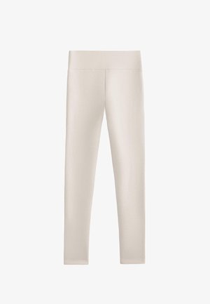 Leggings di un leggero beige realizzati in un materiale liscio e elasticizzato. Presentano una vita alta e larga e una forma aderente, senza cuciture o motivi visibili.