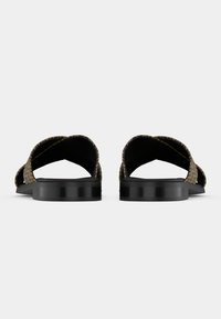 Brune vevde sandaler med teksturert mønster på stroppene og en solid svart platåsåle. Åpen tå-design med X-formede stropper.