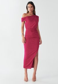 Fuchsia off-shoulder dress with draped design, ruched bodice, thigh-high slit, and ankle-length hem. Made from soft, stretchy fabric.