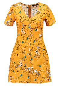 Keltainen kukkakuvioinen mekko, jossa on lyhyet hihat, v-kaula-aukko, nappiyksityiskohdat ja teksturoitu kangas, jossa on sininen ja valkoinen kasviaiheinen kuvio.