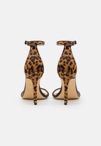 Sandály na vysokém podpatku s leopardím vzorem, otevřenou špičkou, tenkými kotníkovými pásky a stiletto podpatky. Vyrobené z texturované tkaniny s černou podrážkou.