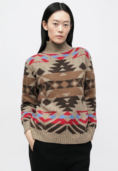 Strikket sweater med høj rullekrave, der har et geometrisk tribal mønster i brun, rød og blå på en beige baggrund, med ribbede manchetter.