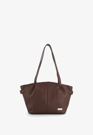 Bruine leren tote bag met een textuurafwerking, twee lange schouderbanden en een goudkleurig accent aan de voorkant. Ruim en gestructureerd ontwerp.