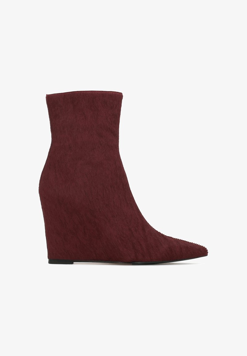 Cizme cu toc wedge, de culoare burgundy, cu vârf ascuțit, realizate dintr-un material texturat asemănător blănii, având o siluetă elegantă și o talpă plată.