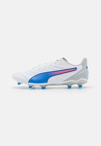 Scarpe da calcio bianche con accenti blu e rosa. Parte superiore in sintetico liscio, pannelli texturizzati, tallone grigio chiaro e tacchetti blu removibili.