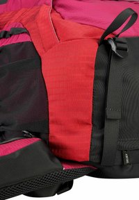 Zaino multicolore caratterizzato da tessuto rosso, rosa e nero con un motivo testurizzato. Include pannelli in rete e spallacci regolabili per un uso ergonomico.