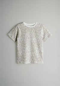 Camiseta de manga corta con base blanca y patrón de estampado de leopardo marrón. Tiene un cuello redondo y una textura suave y lisa.