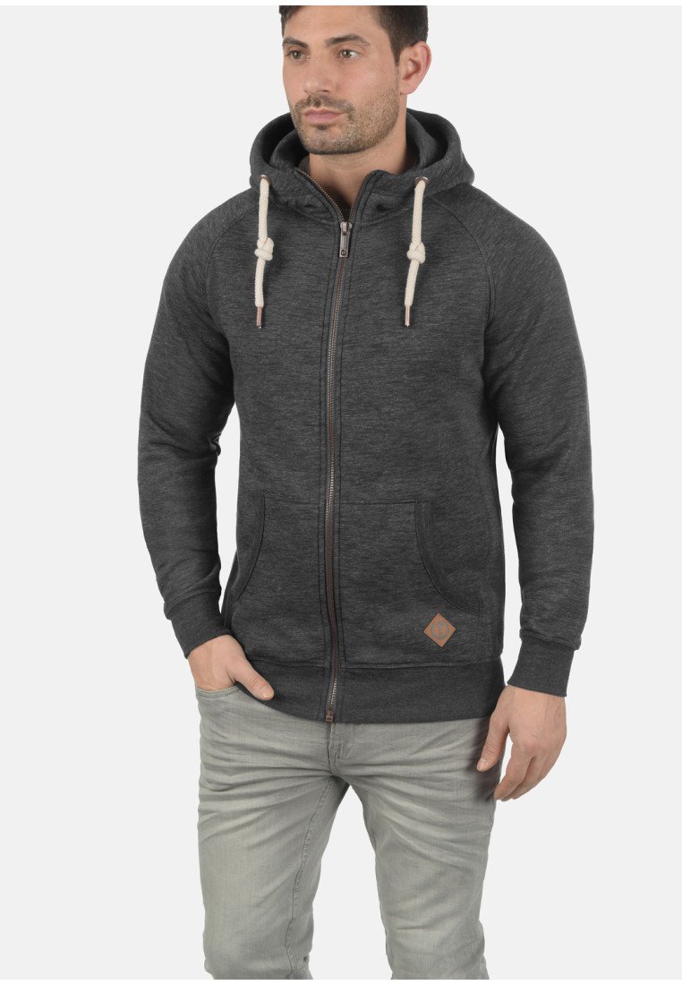 Sudadera con cremallera de color gris oscuro, hecha de un tejido suave, con capucha ajustable, bolsillos frontales y un pequeño parche con logo en el dobladillo.