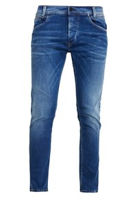 Blå denimjeans med en slank pasform, der har let falmning, fem lommer, lukning med knapper og diskrete syningsdetaljer.