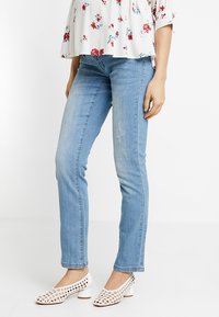 Jeans in denim azzurro chiaro con vestibilità slim, caratterizzati da una leggera scoloritura e whiskering. Abbinati a scarpe bianche con taglio laser.