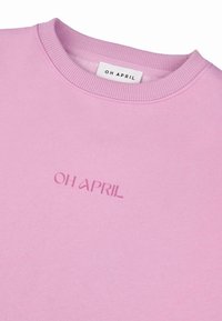Világos rózsaszín pulóver, kerek nyakkal, bordás mandzsettákkal és alsó résszel, az "OH APRIL" felirattal hímzéssel, enyhén sötétebb rózsaszínben. Puha tapintású.