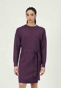 Vestido de malha em roxo profundo com decote redondo, mangas longas, cintura cingida e silhueta reta, apresentando bordas caneladas.